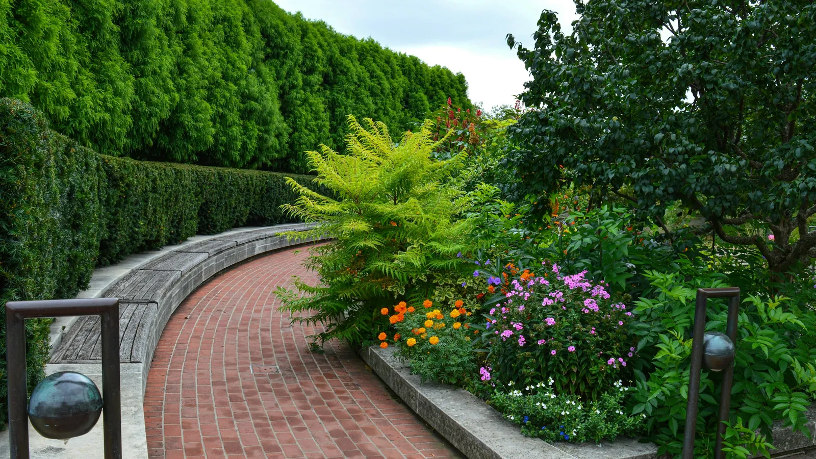 A brick path winding through a flower garden